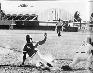 Baseball player sliding to plate.