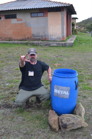 Dr. Randle next to a blue bucket labelled metal