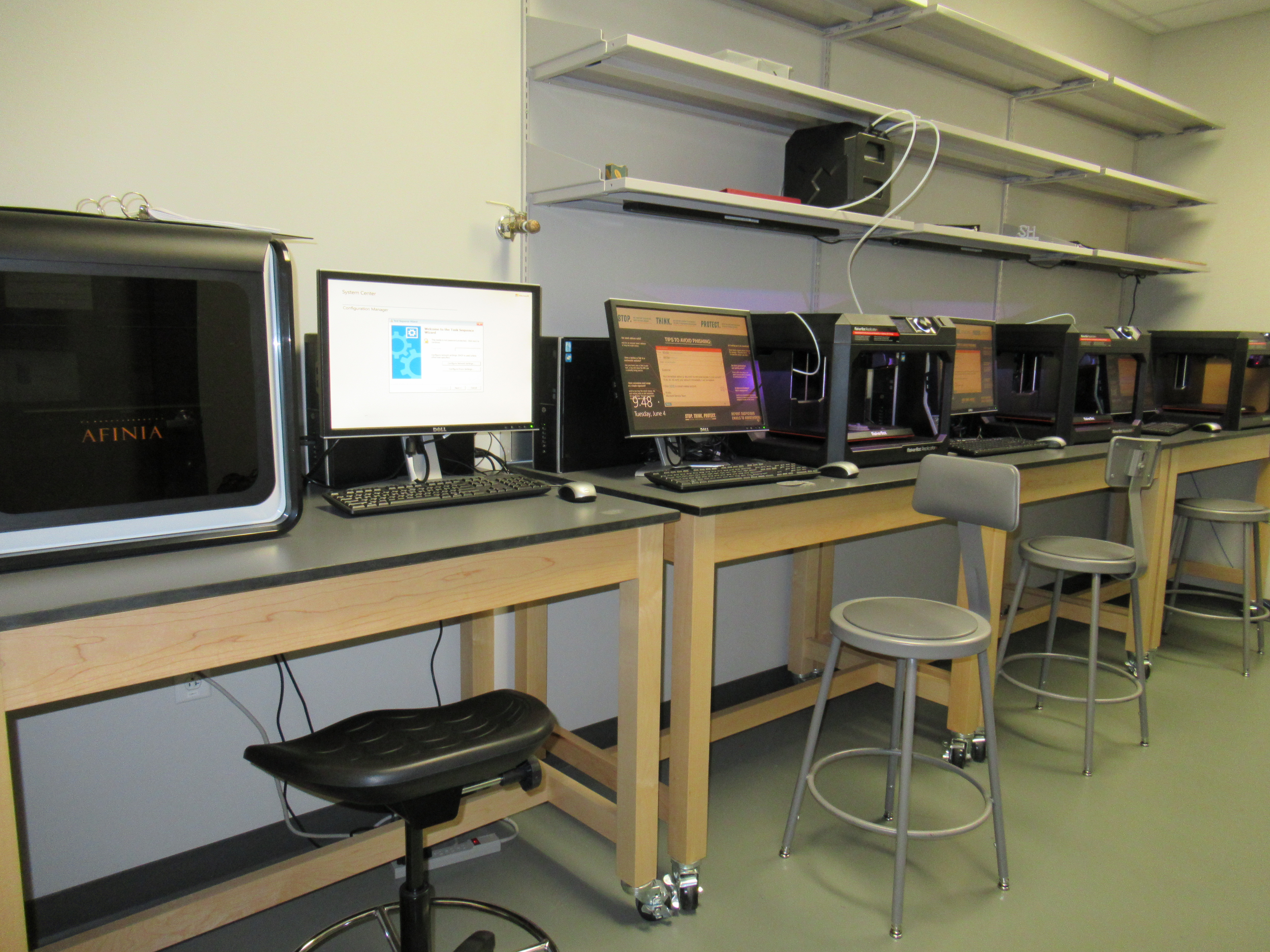 row of computers with a 3d printer at the end