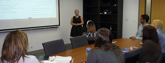 A woman gives a presentation in a conference room.