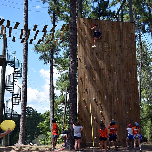 campers doing rock wall with challenge course