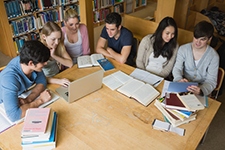 Group of college students studying at the library