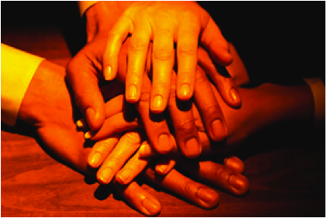 Hands on top of hands indicating togetherness