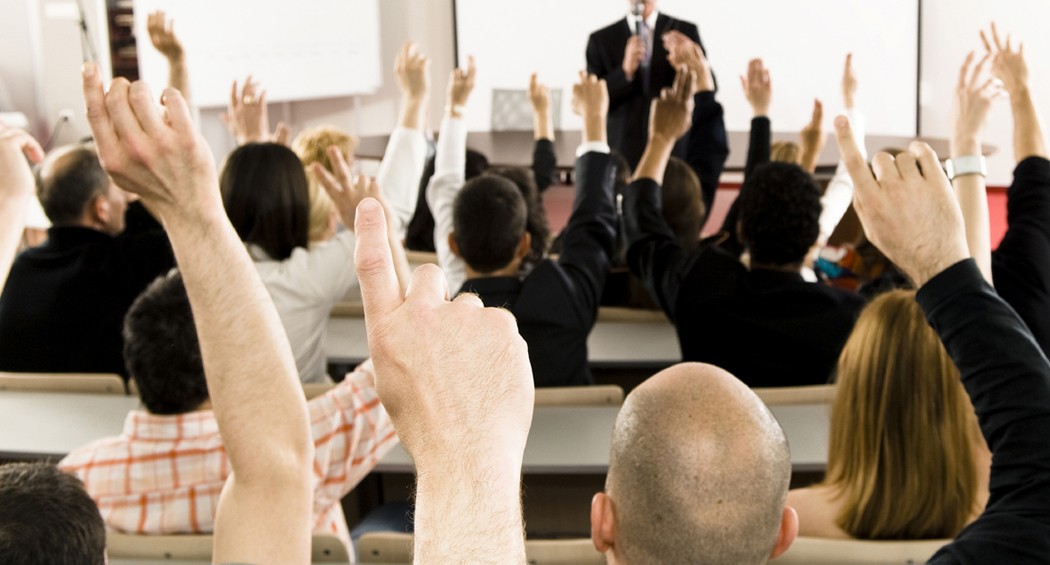 Classroom of professionals raising their hand