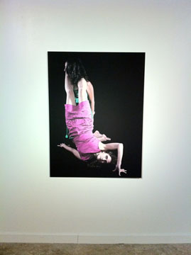 Photo on wall of two women in contorted positions.