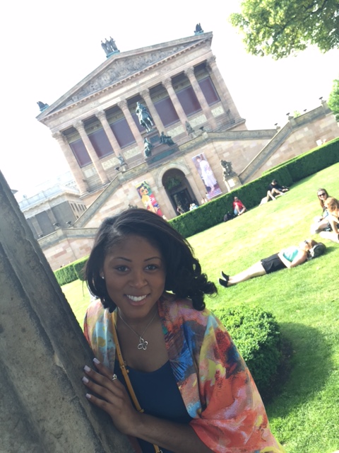 Amshi posing in front of a Neoclassican style building in Europe