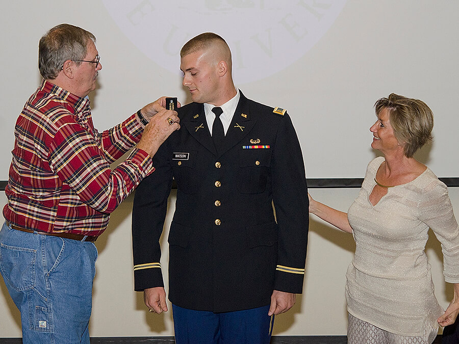 Travis Watson with his parents at his pinning ceremony.