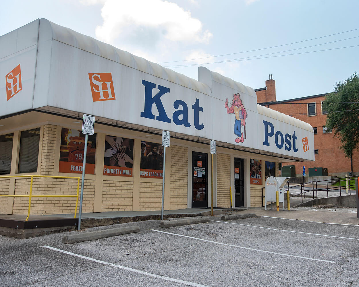 the exterior view of KatPost, a white topped building with sammy the bearkat leaning on a mailbox