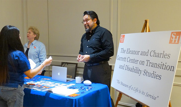 Dr. Jaime B. Durán working at an information table during a conference