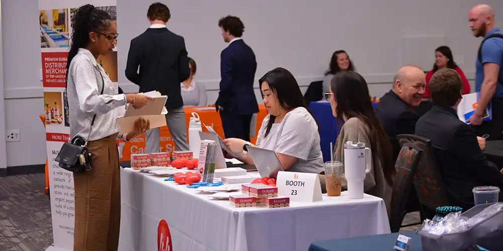 Students meeting with recruiters at their booth at the COBA Business Fair.