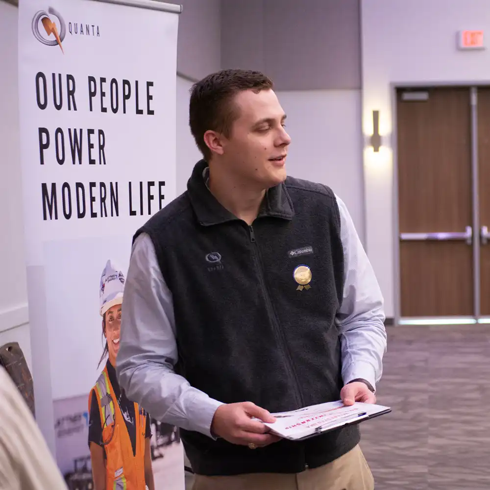 A recruiter looking to the right while holding a clipboard.