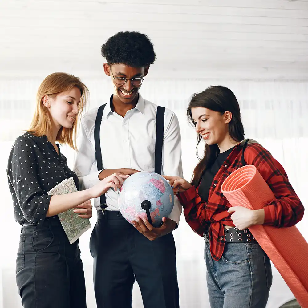Multiple students pointing at a globe.