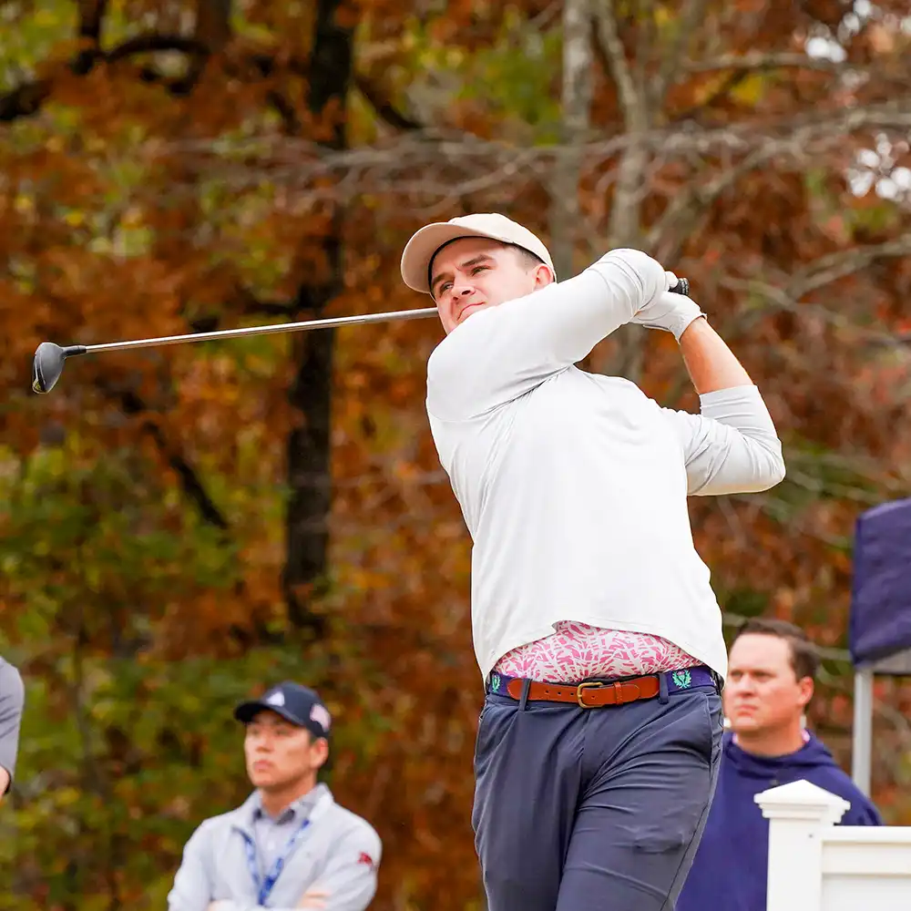 A golf student mid-swing on the course.