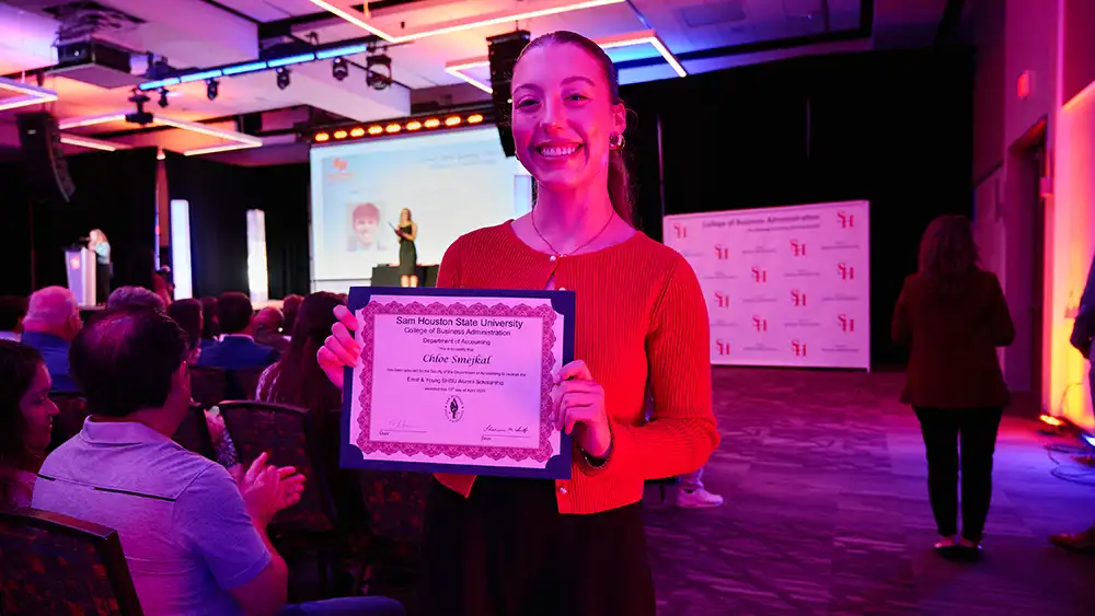 Chloe Smejkal posing with her scholarship award at an event.