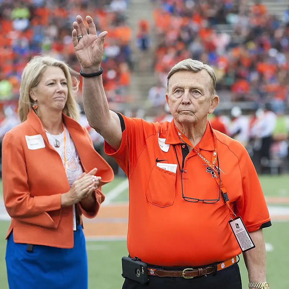 Mr. Bexley with his arm raised at a football game.