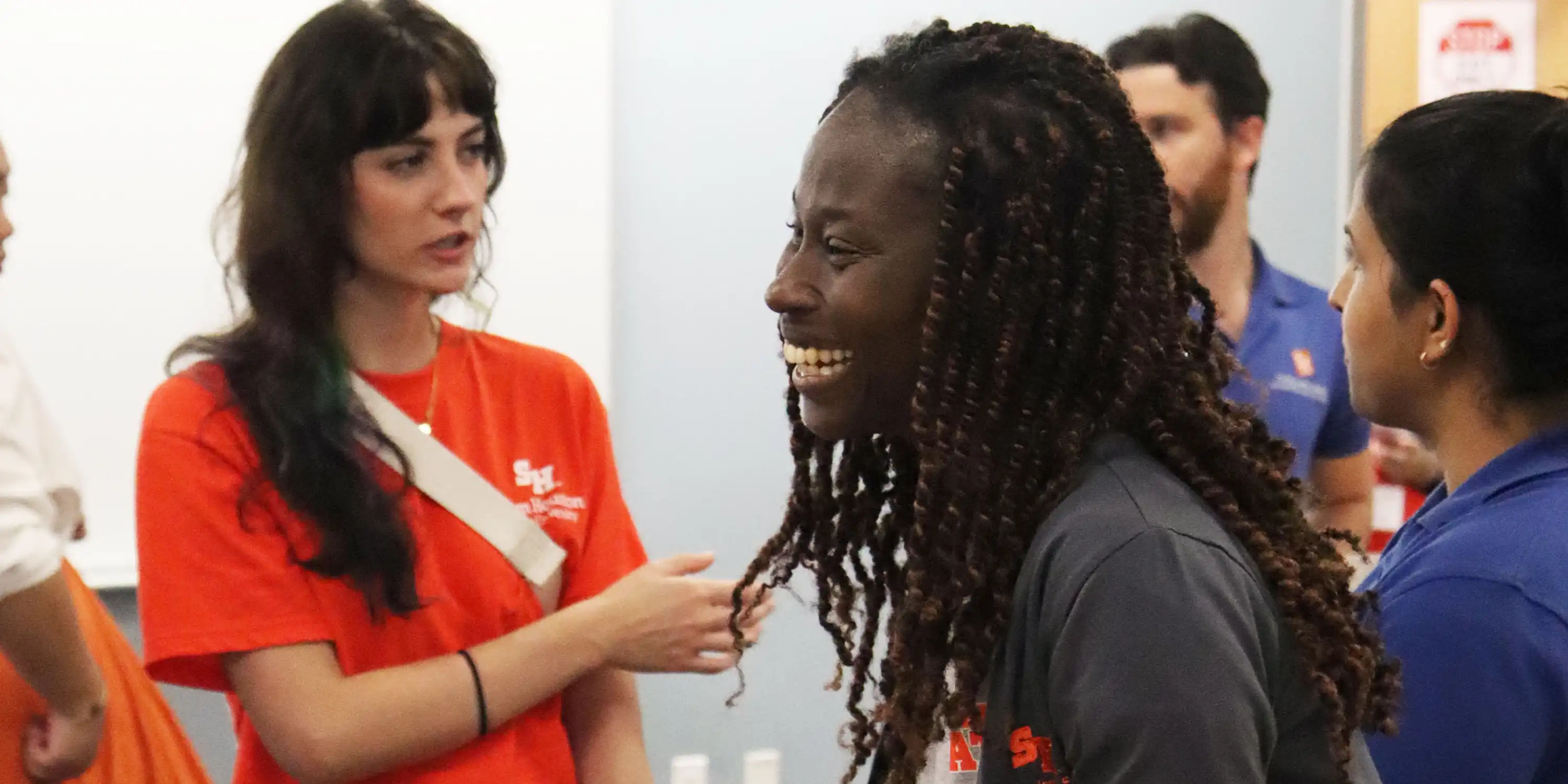 SHSU faculty member has big smiles as she speaks with students and hands out cotton candy.