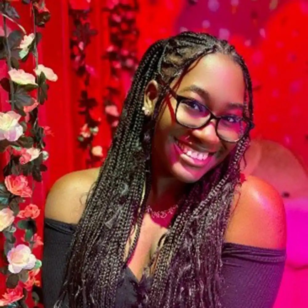 Lakyndra poses, smiling with a red background and red dress.