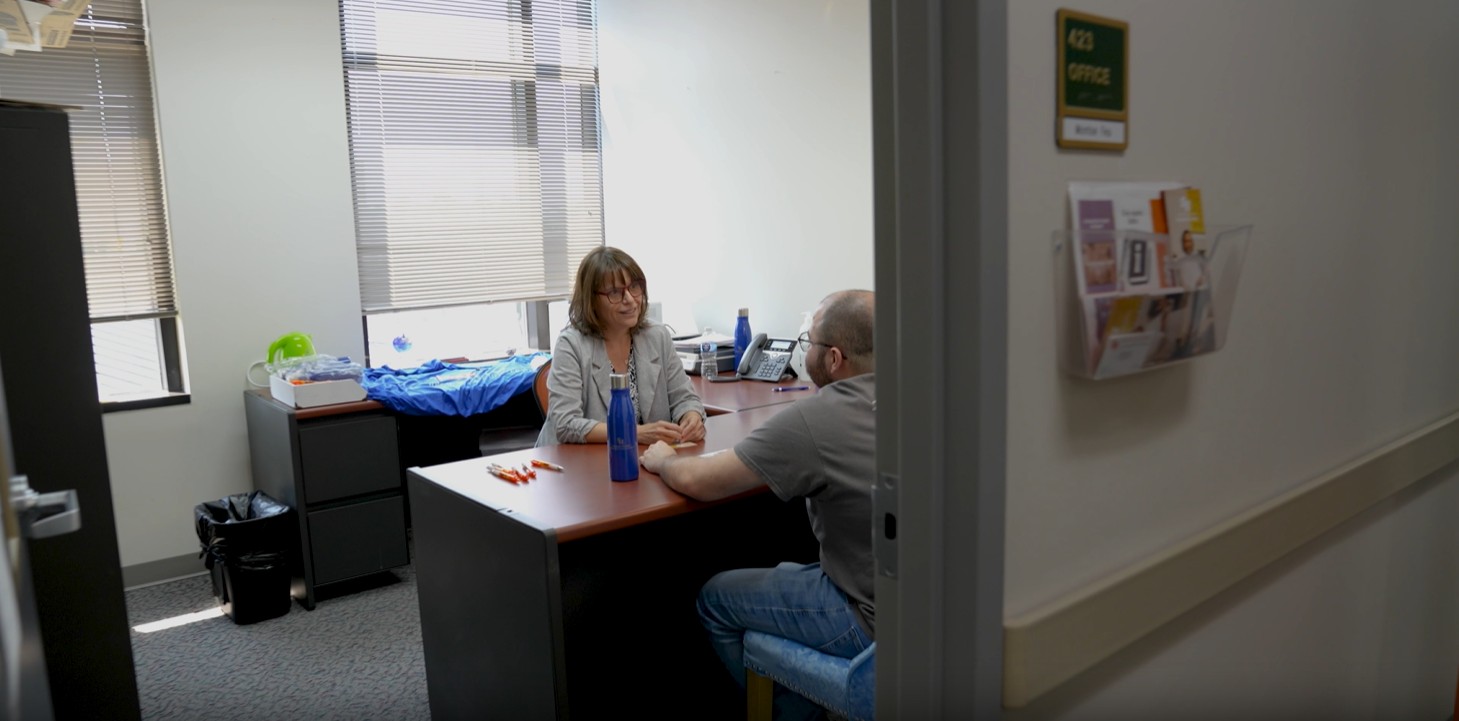 SHSU faculty speaks with a student in her office.