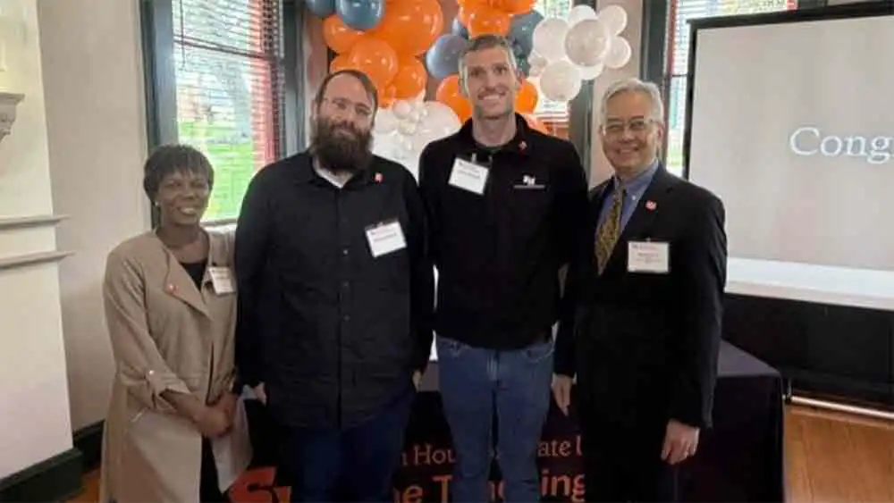 ACUE winners stand with the Dean of CHSS for a photo at the ceremony.