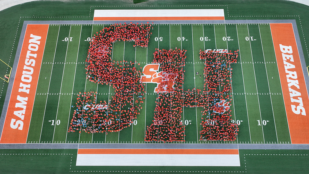 2026 SHSU freshman class forms a giant human SH on the football field.