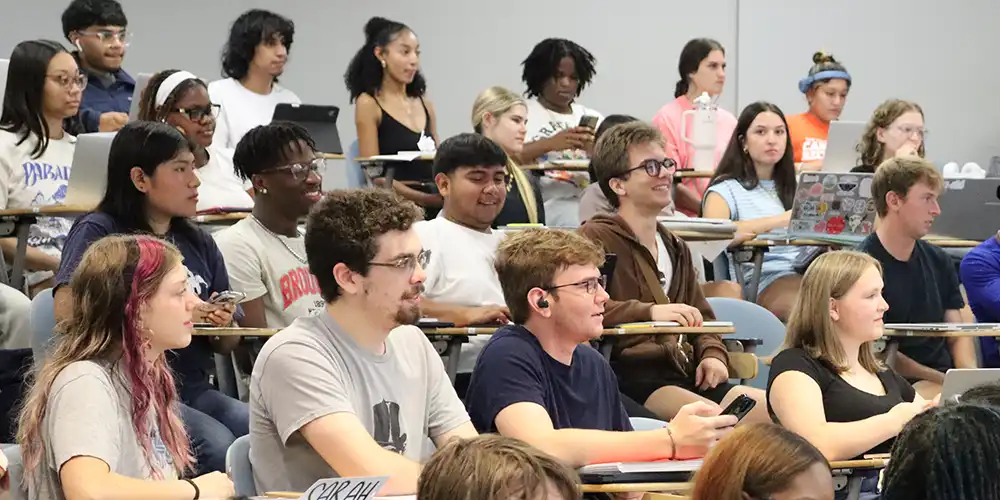 SHSU students laughing while sitting in their seats in a Political Science class.