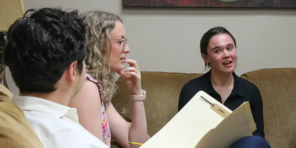 Psychology students speak during a practice therapy session.