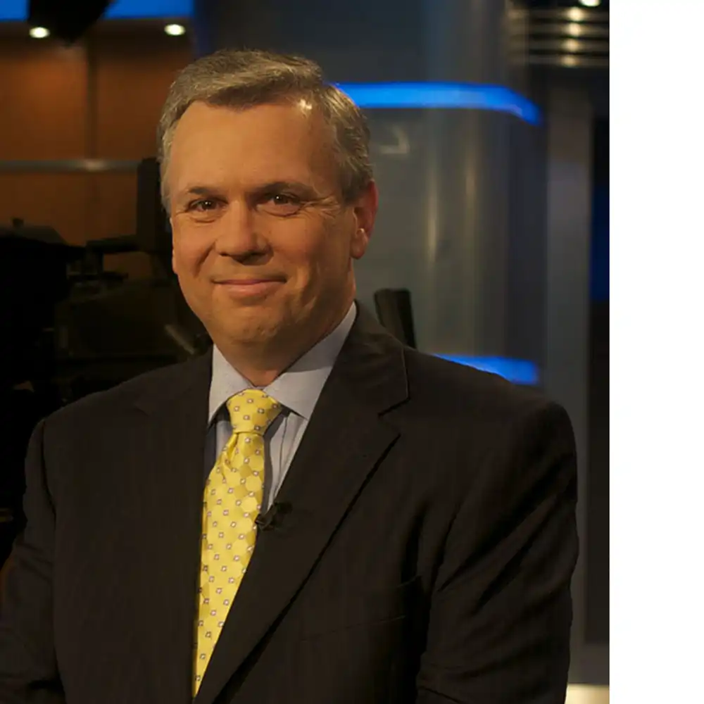 Smiling middle-aged white man in a suit and yellow tie.