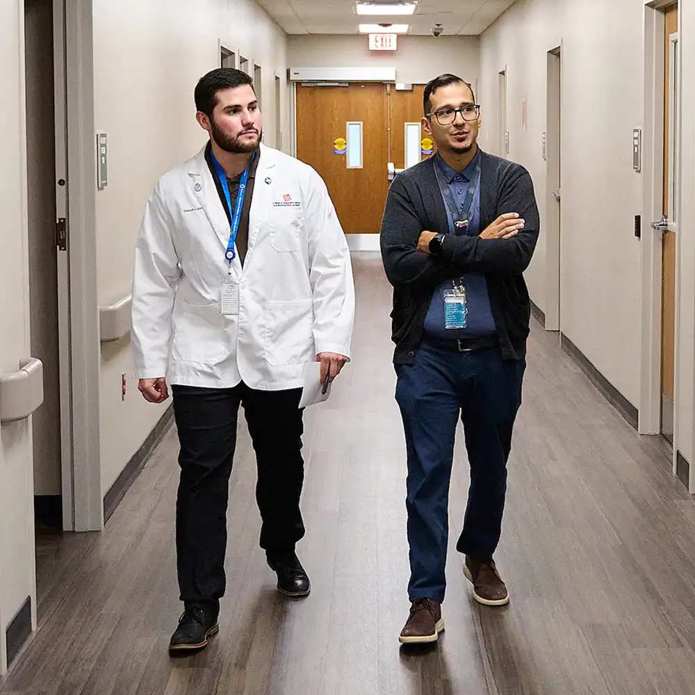 Arms of a patient getting an ultrasound on their wrist by student doctor using ultrasound machine