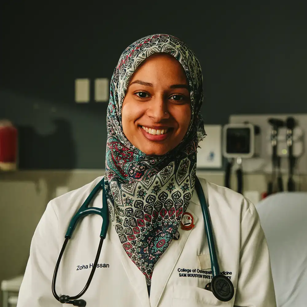 Student doctor smiling for camera with hospital room simulation in the background