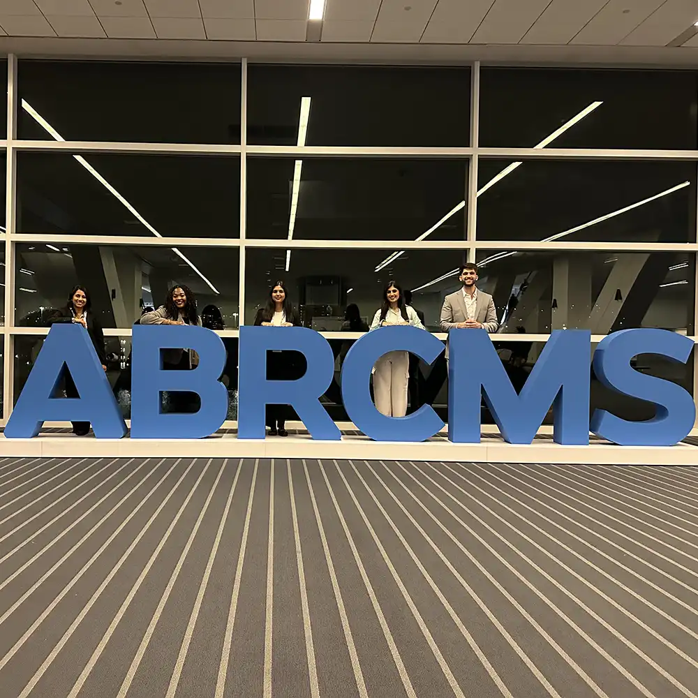 Students standing behind large letters that spell out ABRCMS