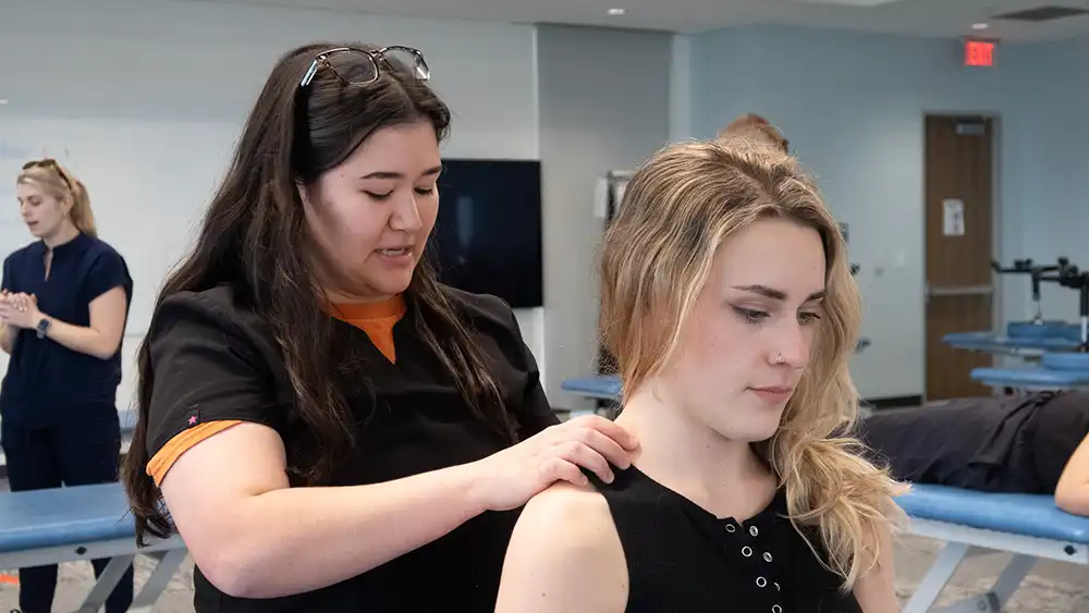 student doctor performing omt on graduate dancer