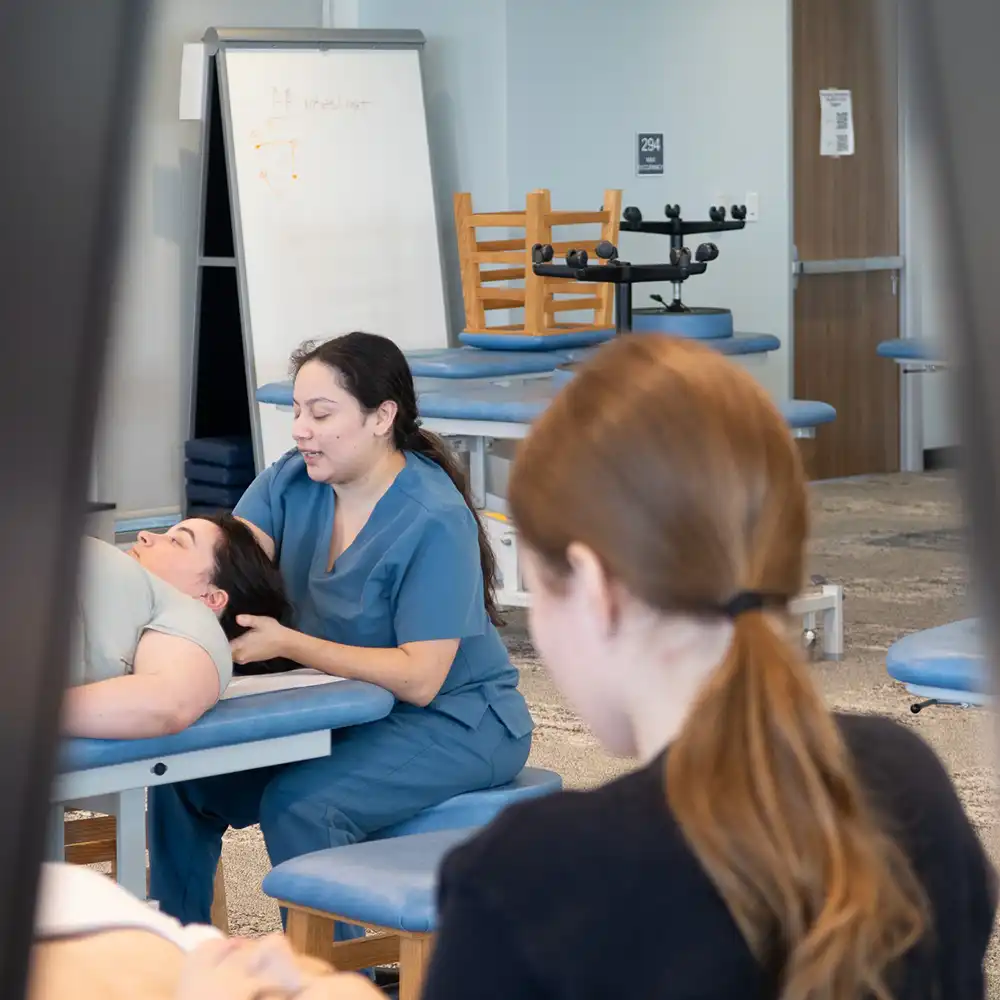 student doctor performing omt on graduate dancer