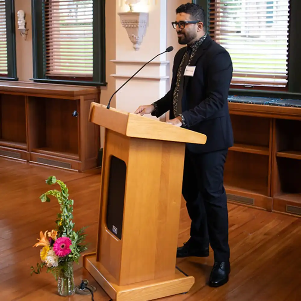 Dr. Youssef standing at a podium and talking to the group