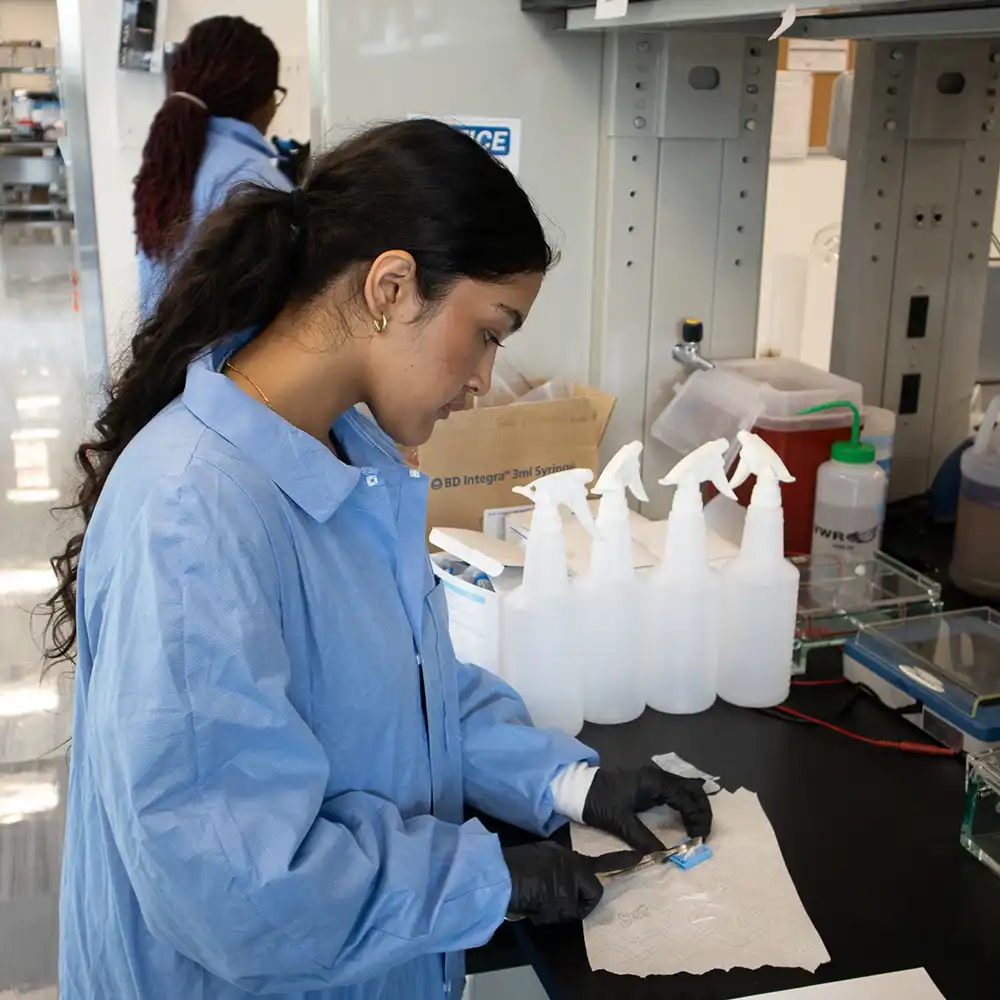 Student preparing something to go on microscope in lab