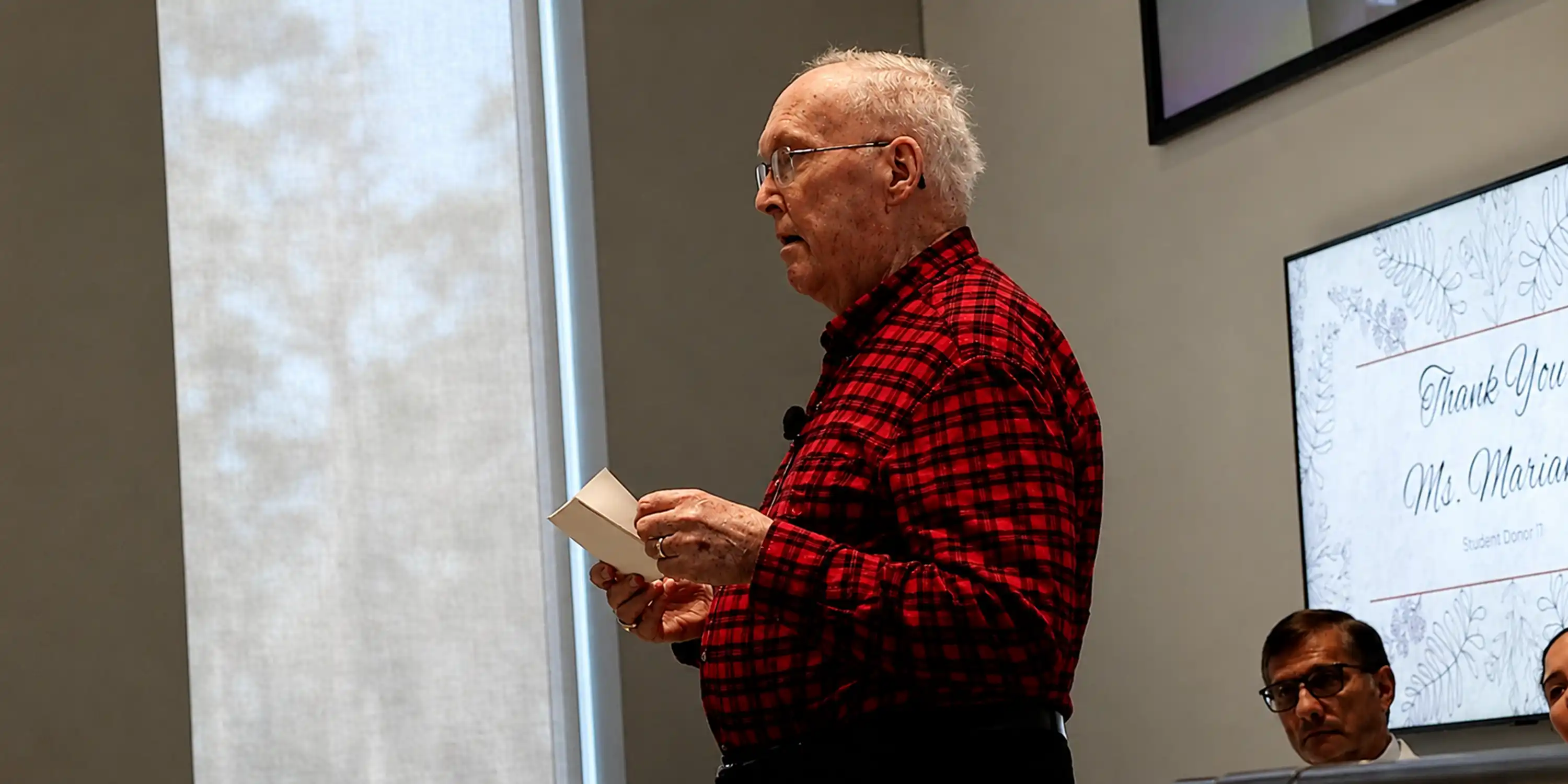 Dr. Rice holding paper speaking to classroom