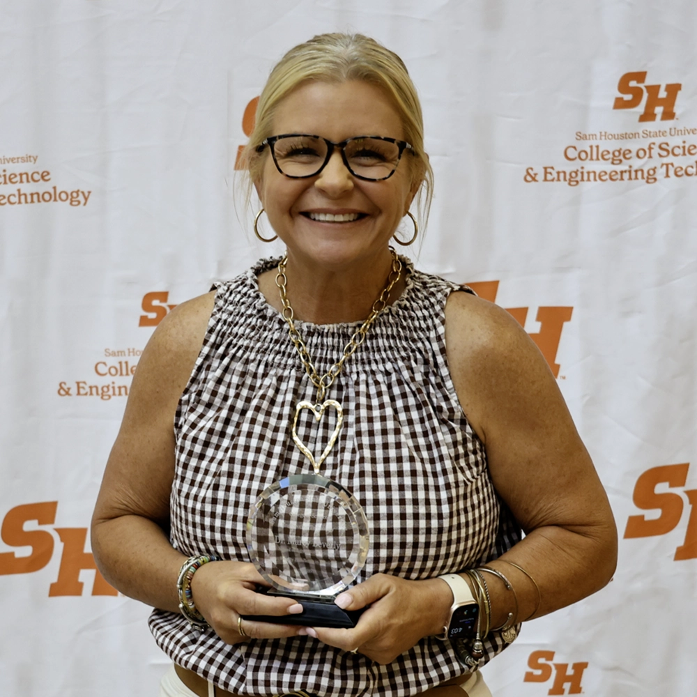 Dr. Beverly holding her award