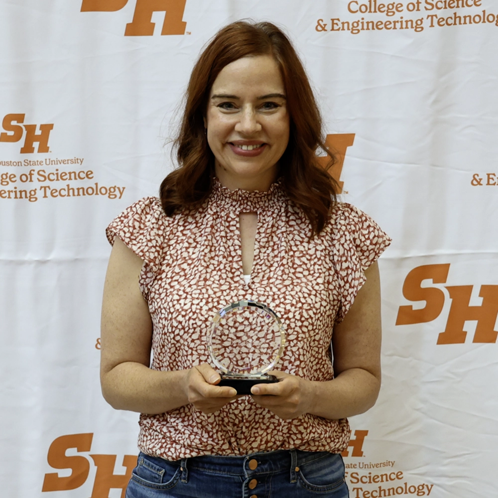 Dr. Cory holding her award