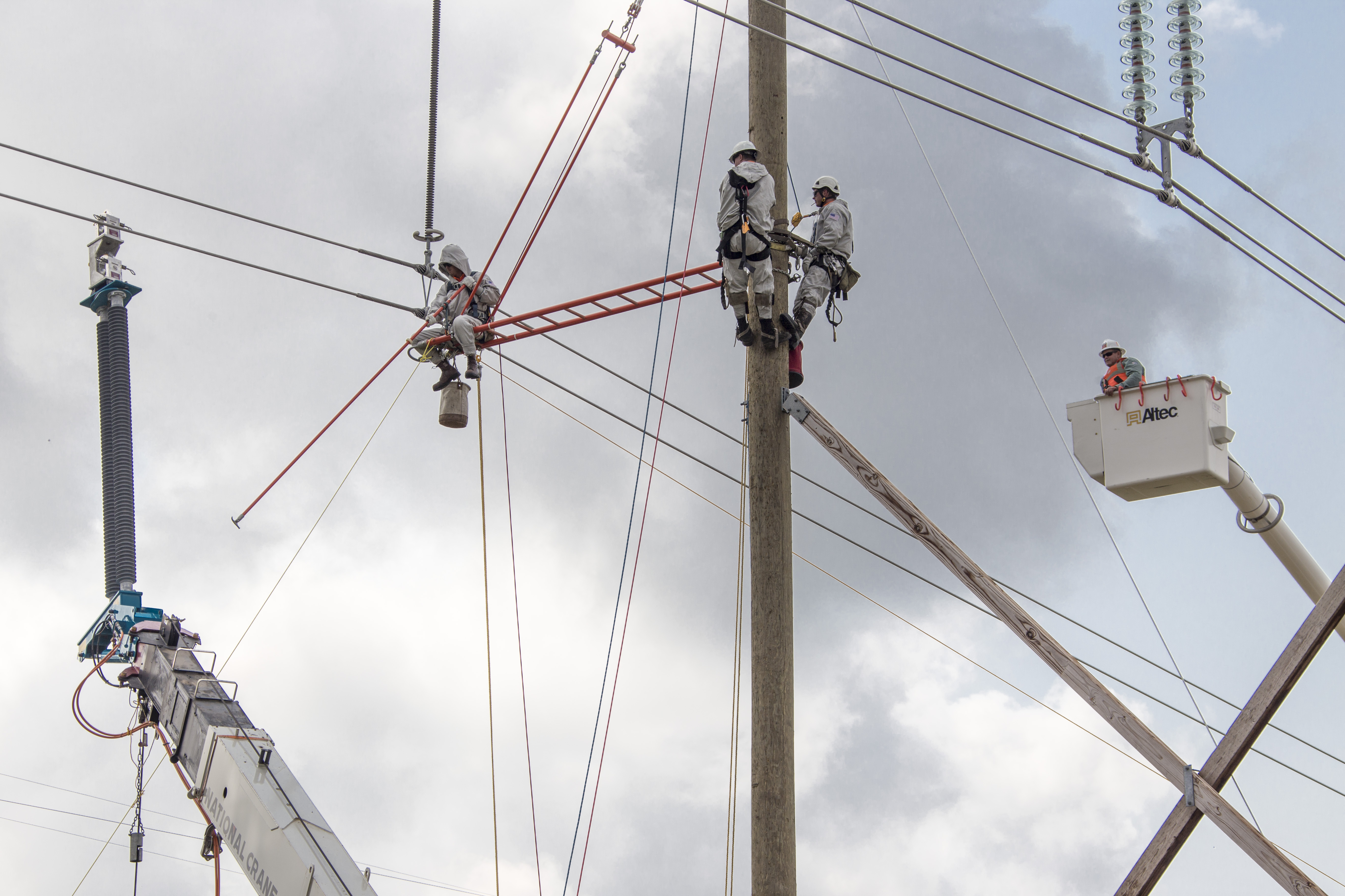 Engineers climbing power poles