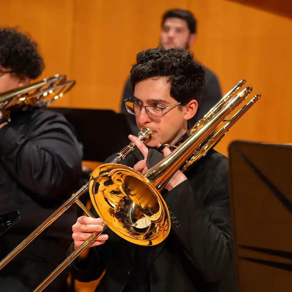 Two women looking at each other, smiling, sitting down, working on an assignment.