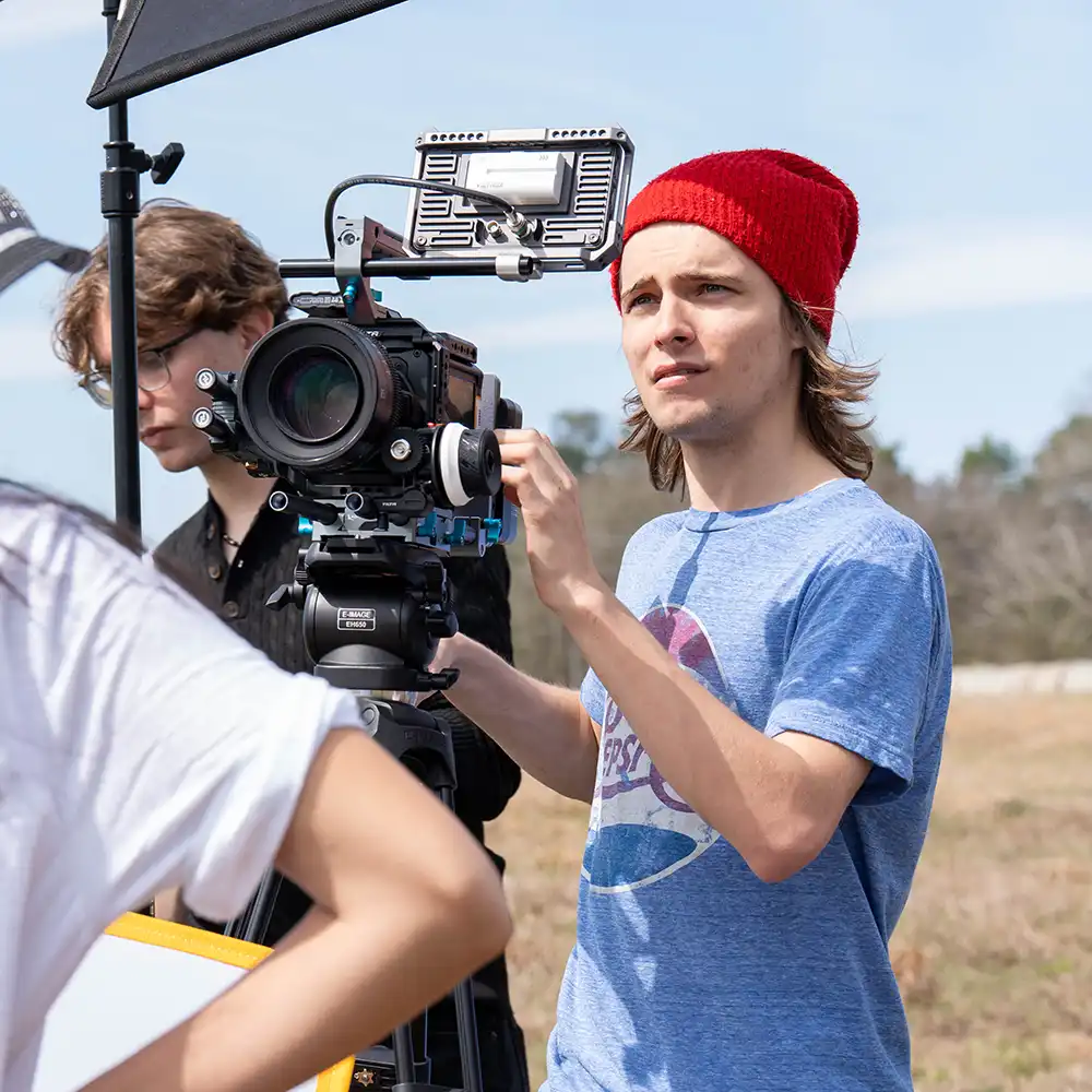 Two women looking at each other, smiling, sitting down, working on an assignment.