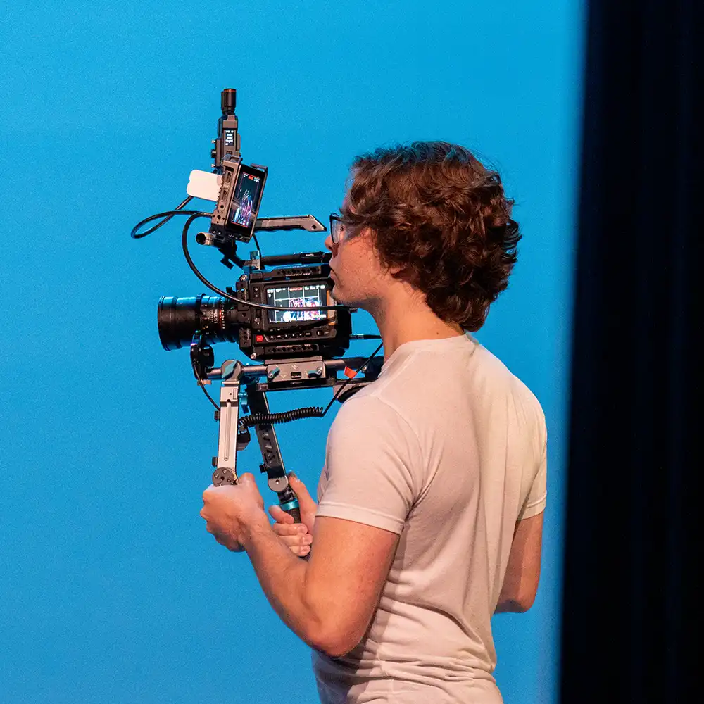 Two women looking at each other, smiling, sitting down, working on an assignment.