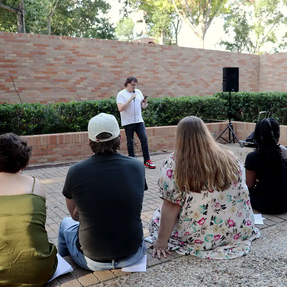Students listening to a creative reading on campus.