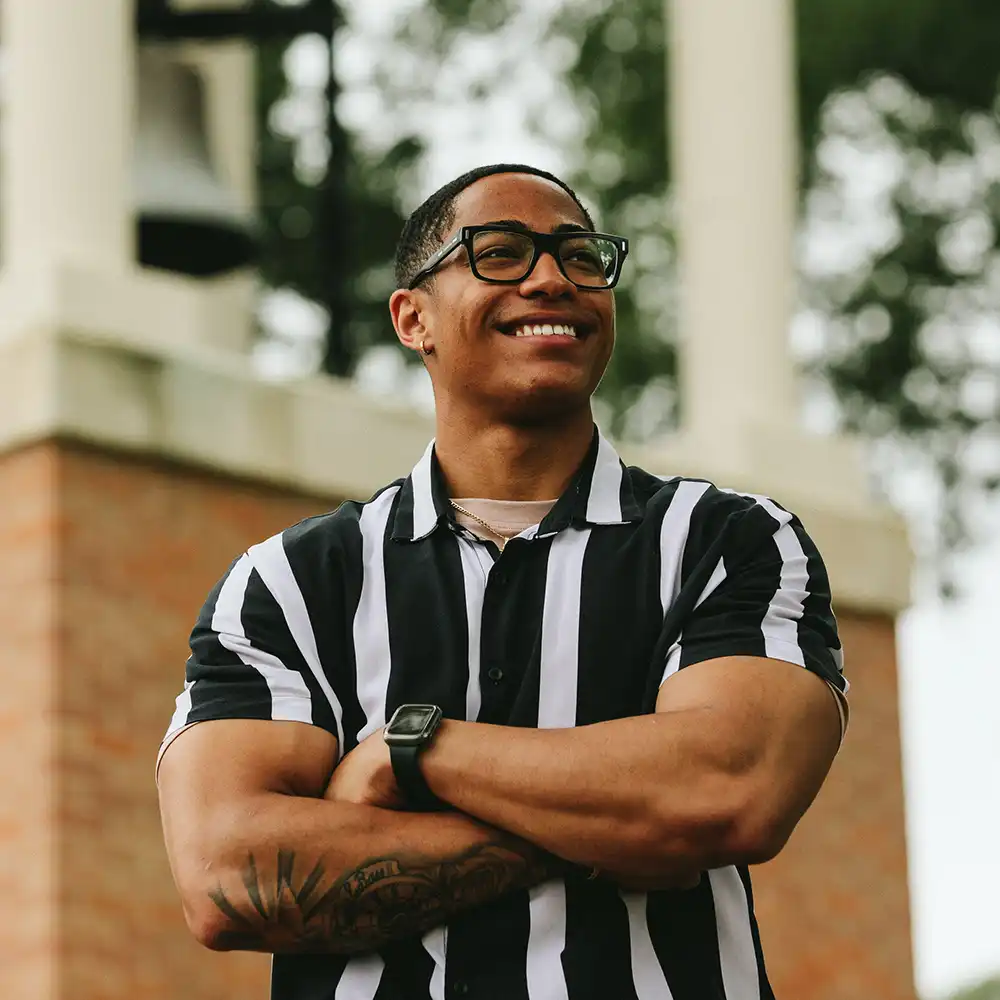 Student standing in front of SHSU clock tower