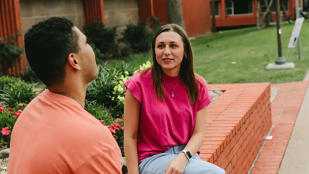 Student deep in conversation outside on campus.