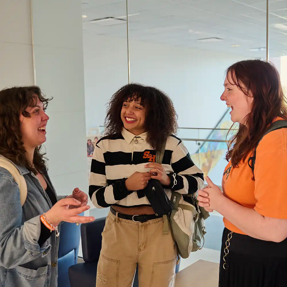 SHSU students in conversation in the College of Humanities and Social Sciences building.