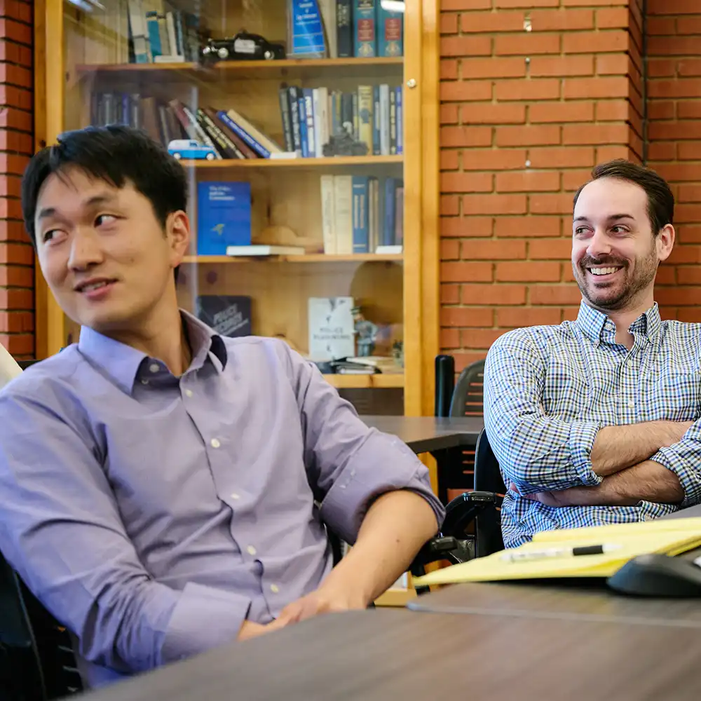 Graduate students smiling while engaged in classroom conversation