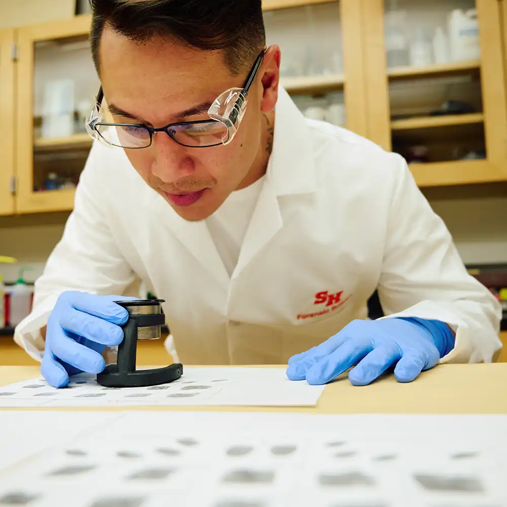 Two women looking at each other, smiling, sitting down, working on an assignment.