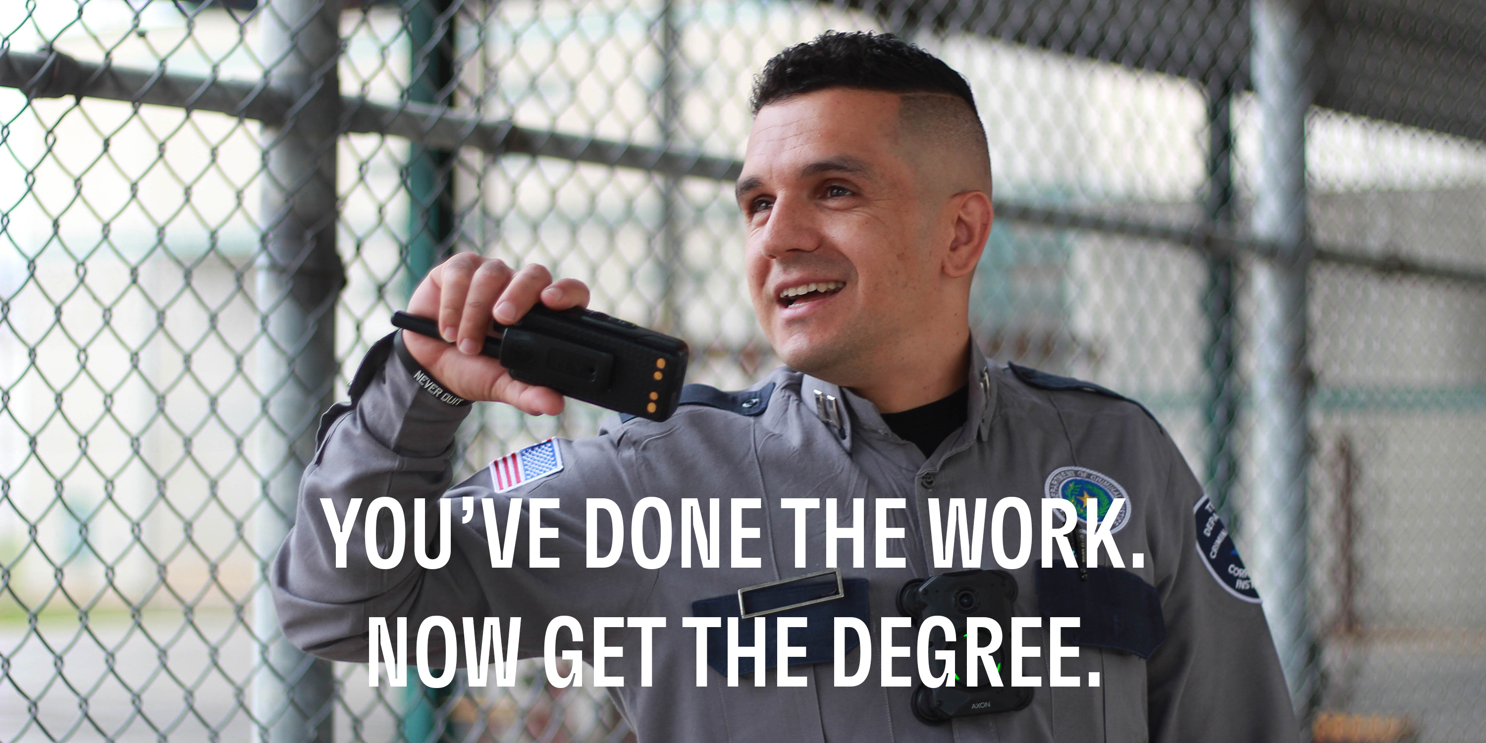Corrections officer in uniform speaking on 2-way radio with a text overlay headline that says "You've done the work. Now get the degree."