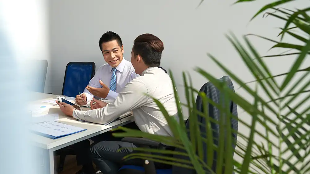 Man in suit talking to another man