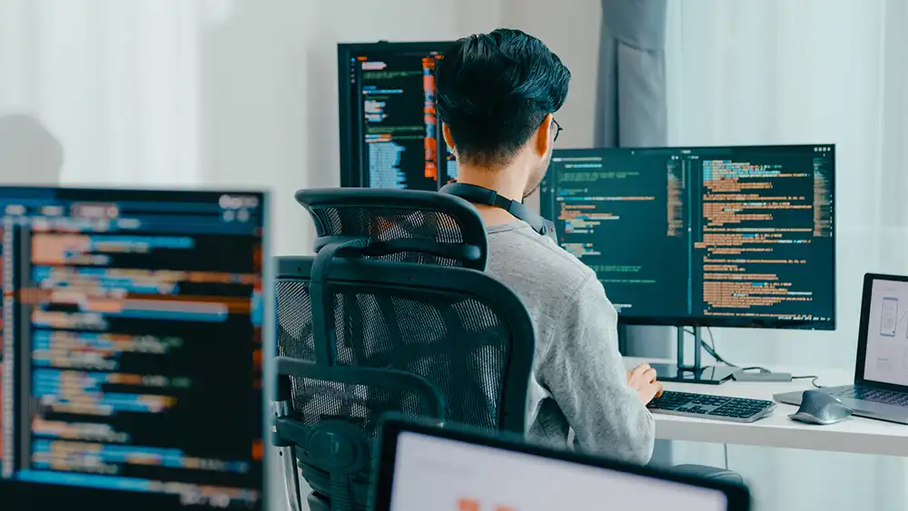 Student working at a computer with code on the screen. 